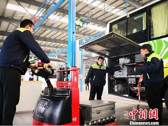 圖為工作人員在給新能源車輛安裝蓄電池。魏建軍 攝