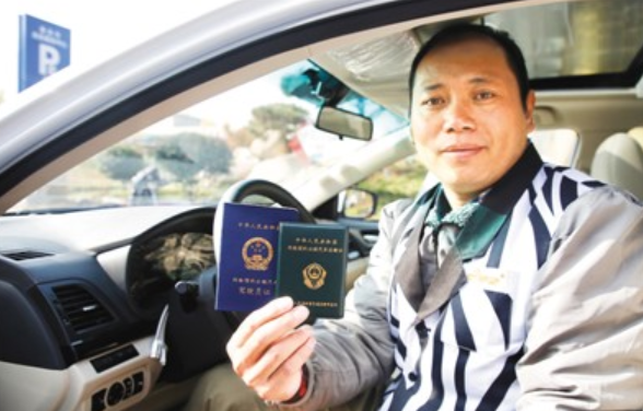 山東泰安，一位網約車司機展示手中的網約車從業資格證